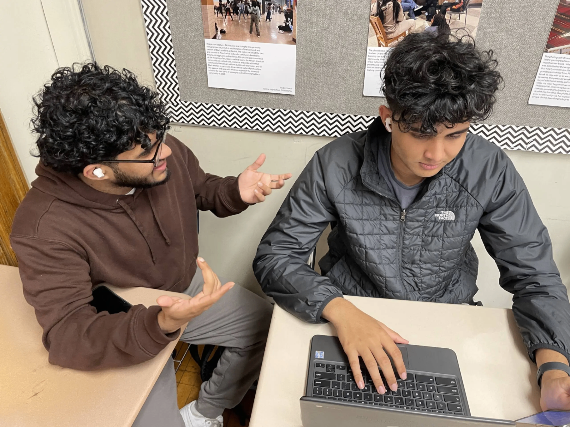 Two students collaborating on a laptop after school.