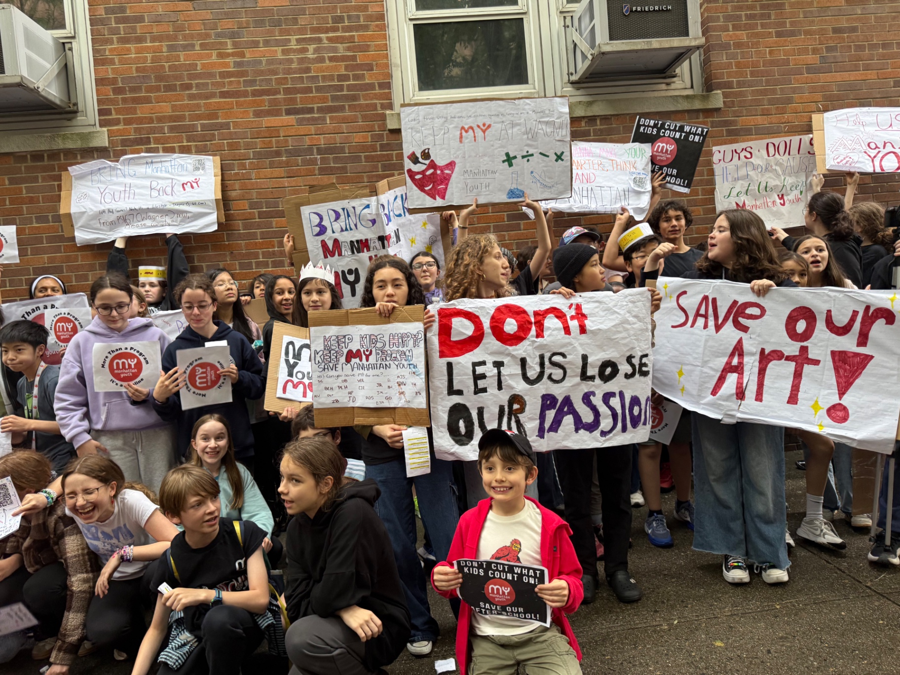 Parents and students with handmade signs at the J.H.S. 167 Wagner rally