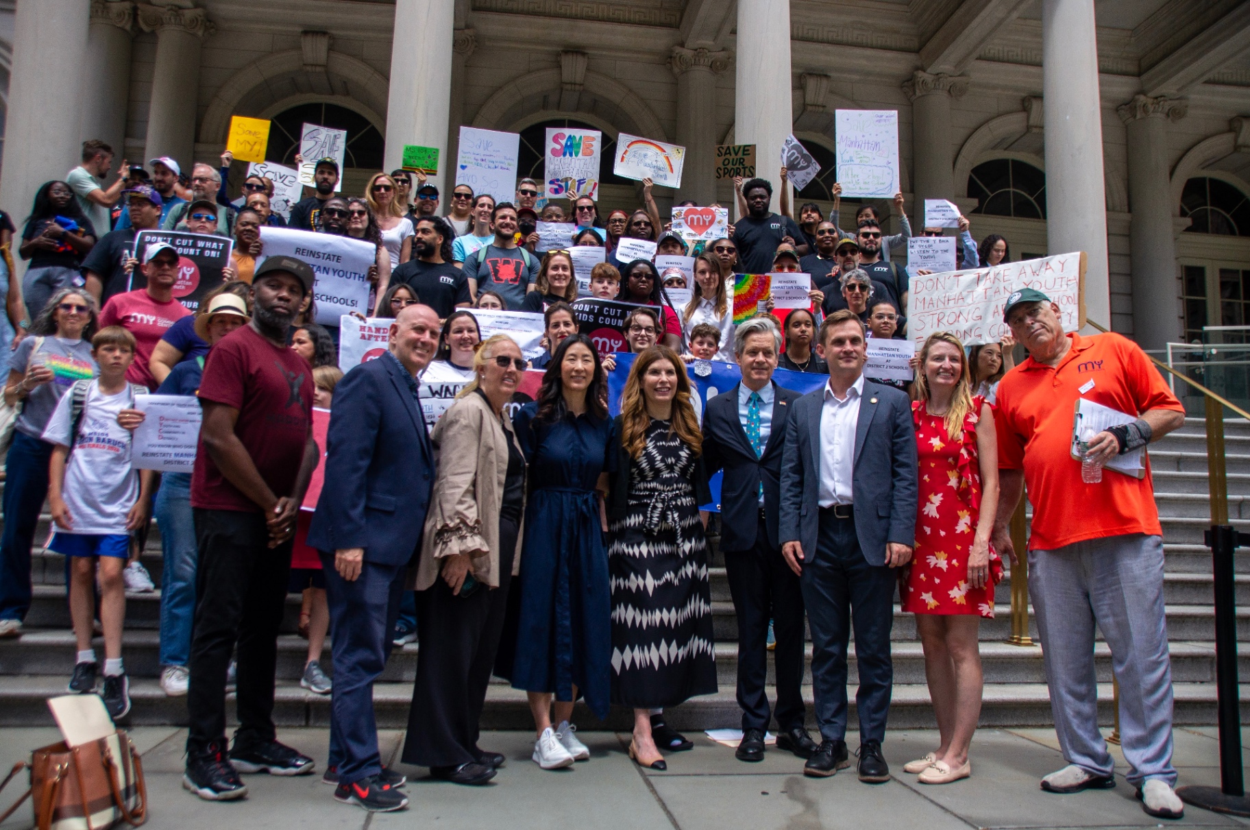 Elected officials stand with parents, students, and frontline staff.